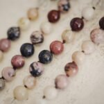 A close-up view of colorful beaded bracelets on a textured surface, showcasing natural stone textures.