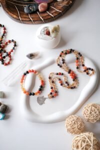 A beautiful flat lay display of handmade gemstone bracelets and necklaces on a decorative tray.
